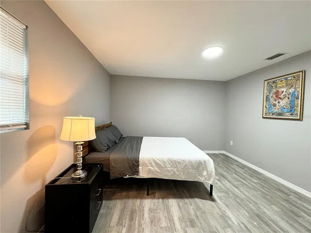 a bedroom with a bed wall painting and a window