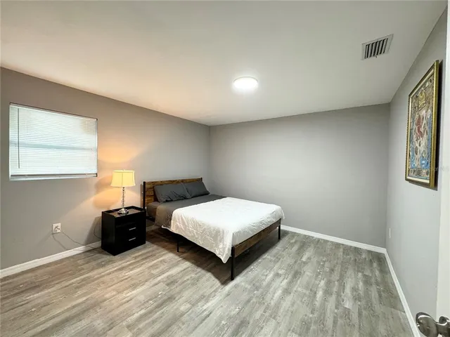 a bedroom with a bed lamp and window