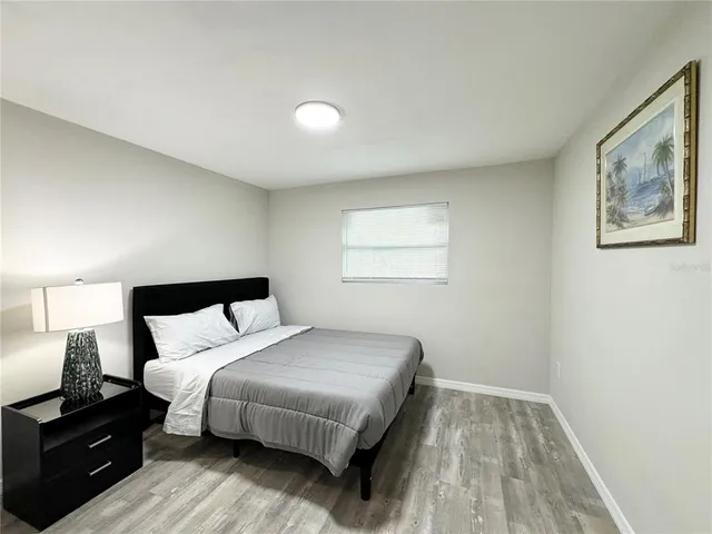 a bedroom with a bed and wooden floor