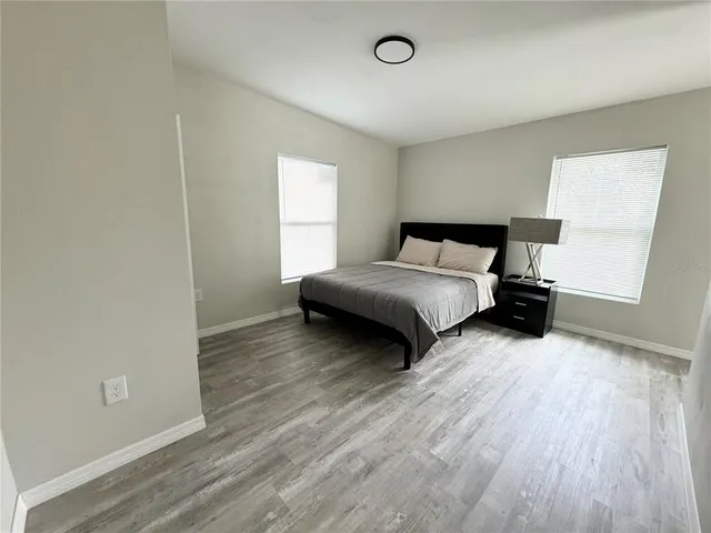 a bedroom with a bed and wooden floor