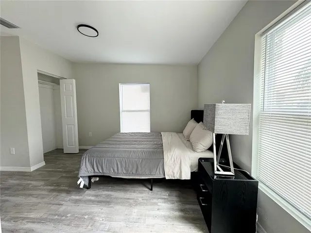 a bedroom with a bed and wooden floor