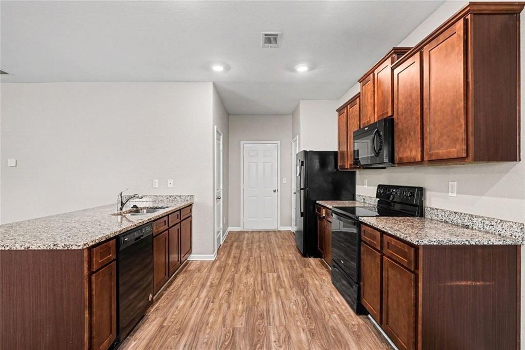 10941 Wheeler Trace Hampton, GA 30228 - Photo 7 of 21 a kitchen with granite countertop a stove top oven and sink