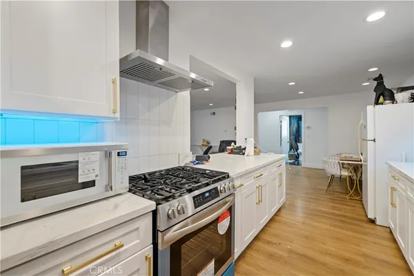 a view of kitchen with stainless steel appliances a refrigerator and a stove top oven