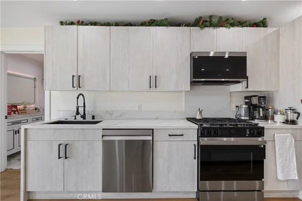 a kitchen with stainless steel appliances granite countertop a sink a stove a refrigerator a microwave and cabinets