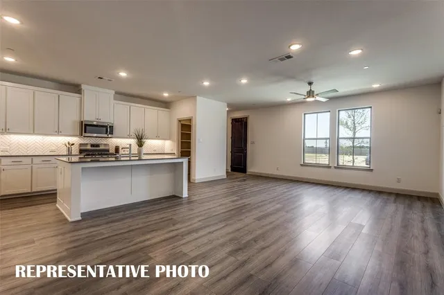 a kitchen with granite countertop a sink and cabinets