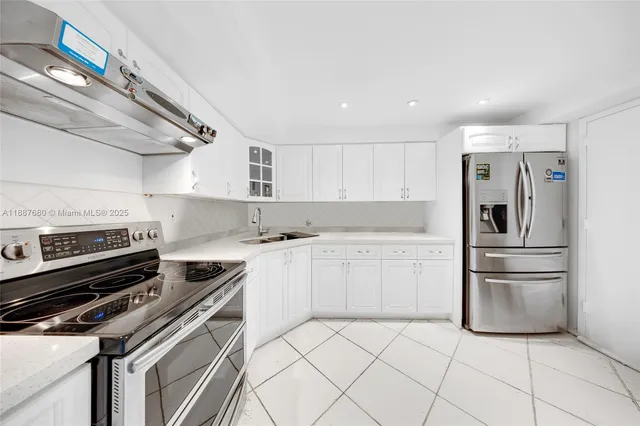 a kitchen with granite countertop white cabinets and appliances