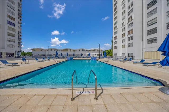 a swimming pool with buildings in the background