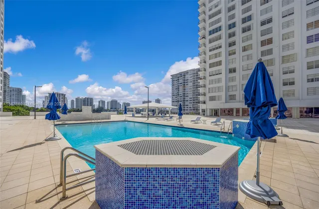 a row of palm trees and swimming pool in the backyard of a building