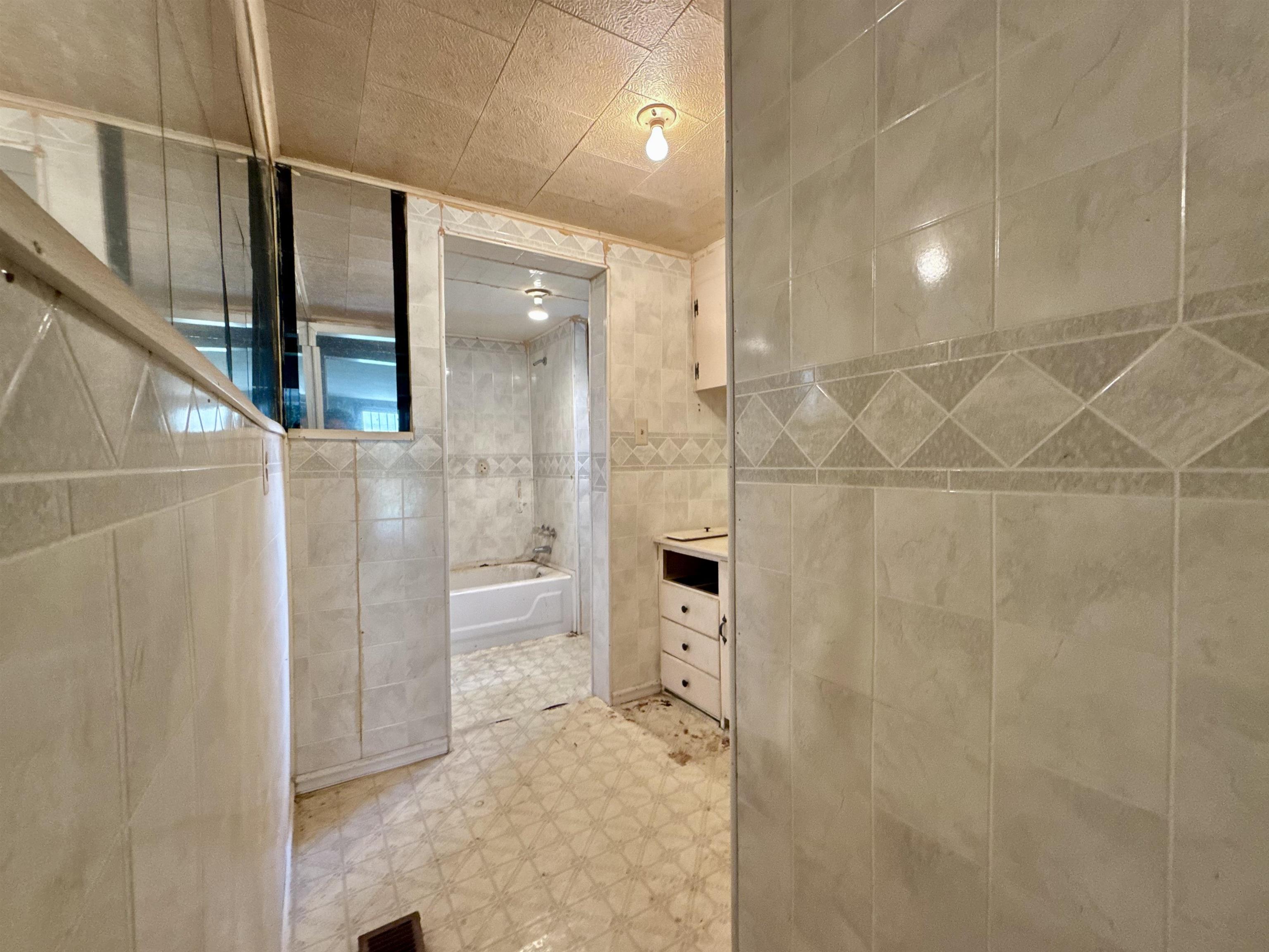 845 Needham Road Drummonds, TN 38023 - Photo 13 of 22 Bathroom with tile walls, vanity, light floors, and shower combination