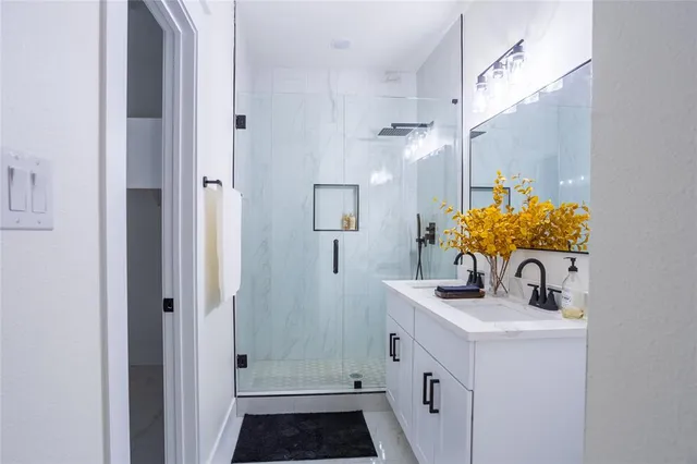 a bathroom with a sink a mirror a vanity and a shower