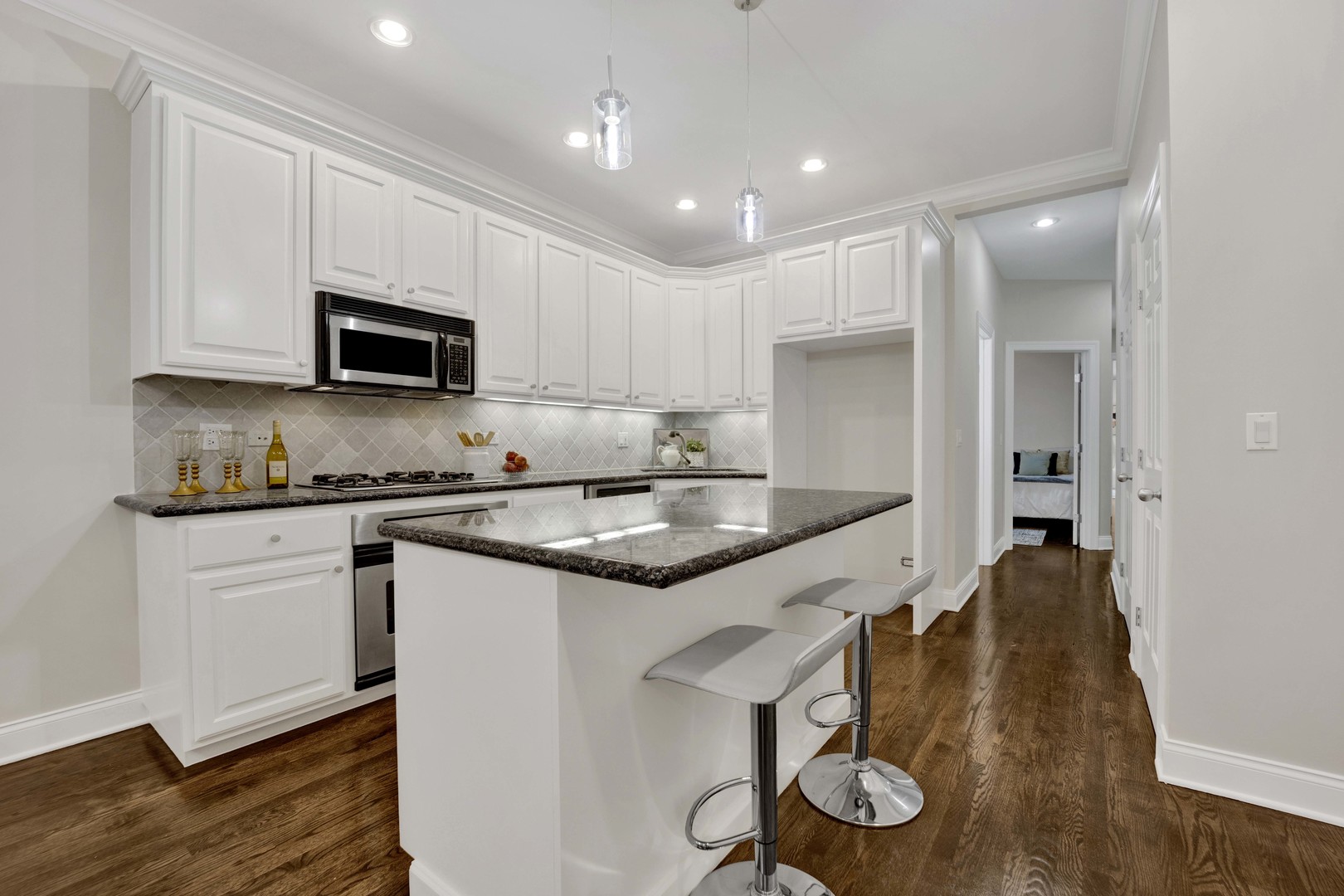 1724 North Mohawk Street, Unit 2 Chicago, IL 60614 - Photo 5 of 24 a kitchen with granite countertop kitchen island white cabinets and stainless steel appliances