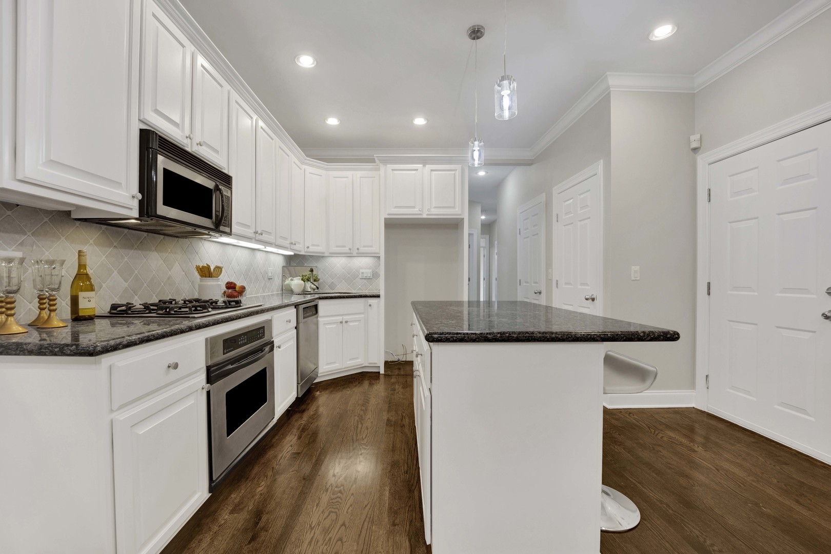 1724 North Mohawk Street, Unit 2 Chicago, IL 60614 - Photo 6 of 24 a kitchen with granite countertop white cabinets and white appliances