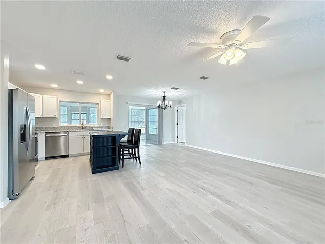 a view of kitchen with stainless steel appliances refrigerator oven and cabinets