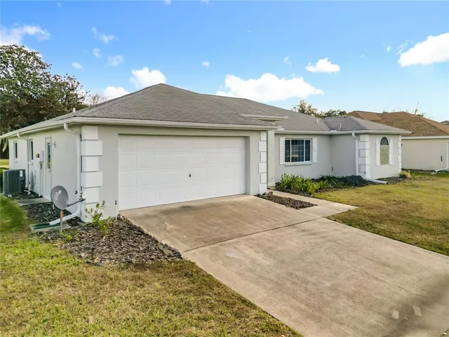 a view of a house with a backyard and a tree