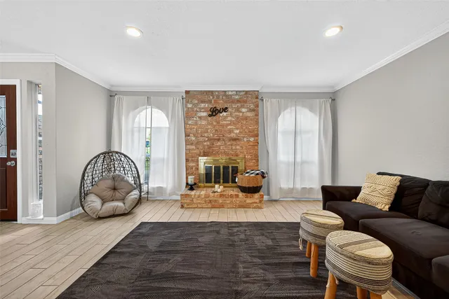 a living room with furniture a large window and wooden floor