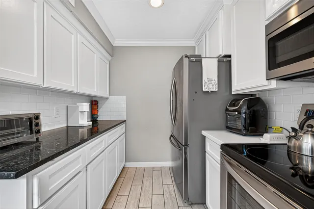 a kitchen with stainless steel appliances granite countertop a refrigerator sink and stove