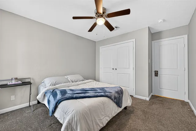 a bedroom with a bed and ceiling fan