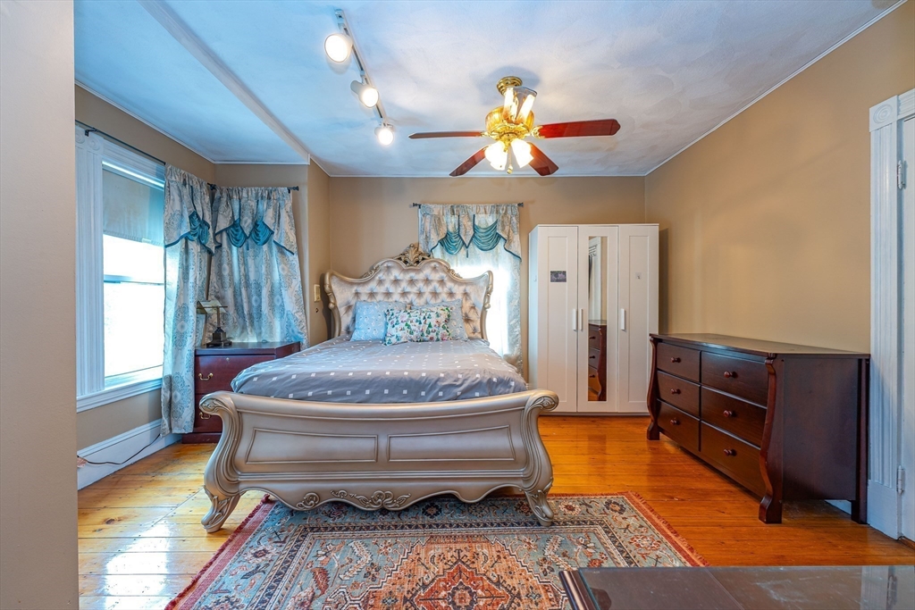 96 Clark Street Everett, MA 02149 - Photo 12 of 26 a bedroom with furniture and a chandelier