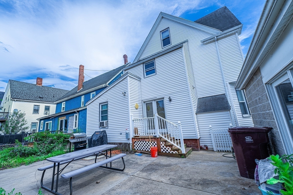 96 Clark Street Everett, MA 02149 - Photo 22 of 26 a view of a chairs and table in the back yard of the house