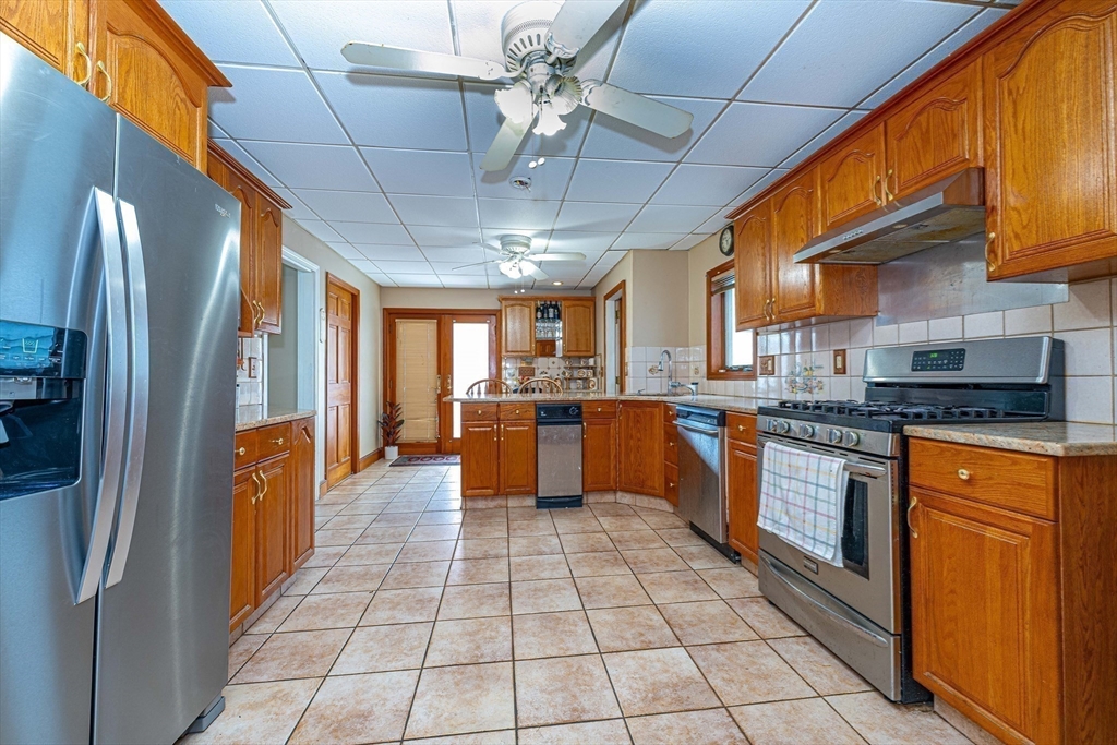 96 Clark Street Everett, MA 02149 - Photo 9 of 26 a kitchen with stainless steel appliances granite countertop a refrigerator a sink a stove top oven and cabinets
