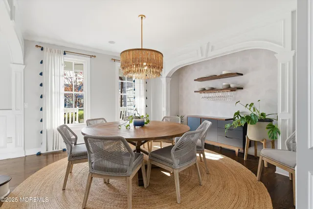 a dining room with furniture a chandelier and wooden floor
