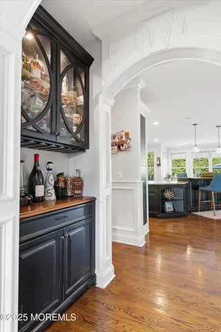 a view of a dining room and livingroom furniture wooden floor a rug and a chandelier