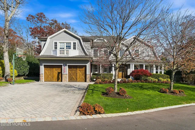 a front view of a house with a garden and trees