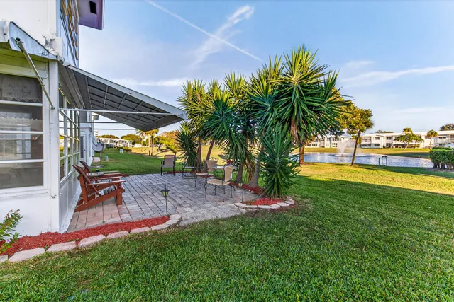 a view of a backyard with table and chairs under an umbrella