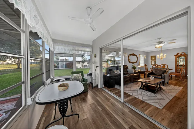 a living room with furniture kitchen view and a wooden floor