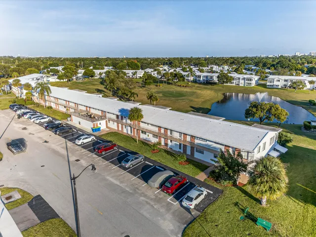 a view of a house with brick walls and flower plants next to a road