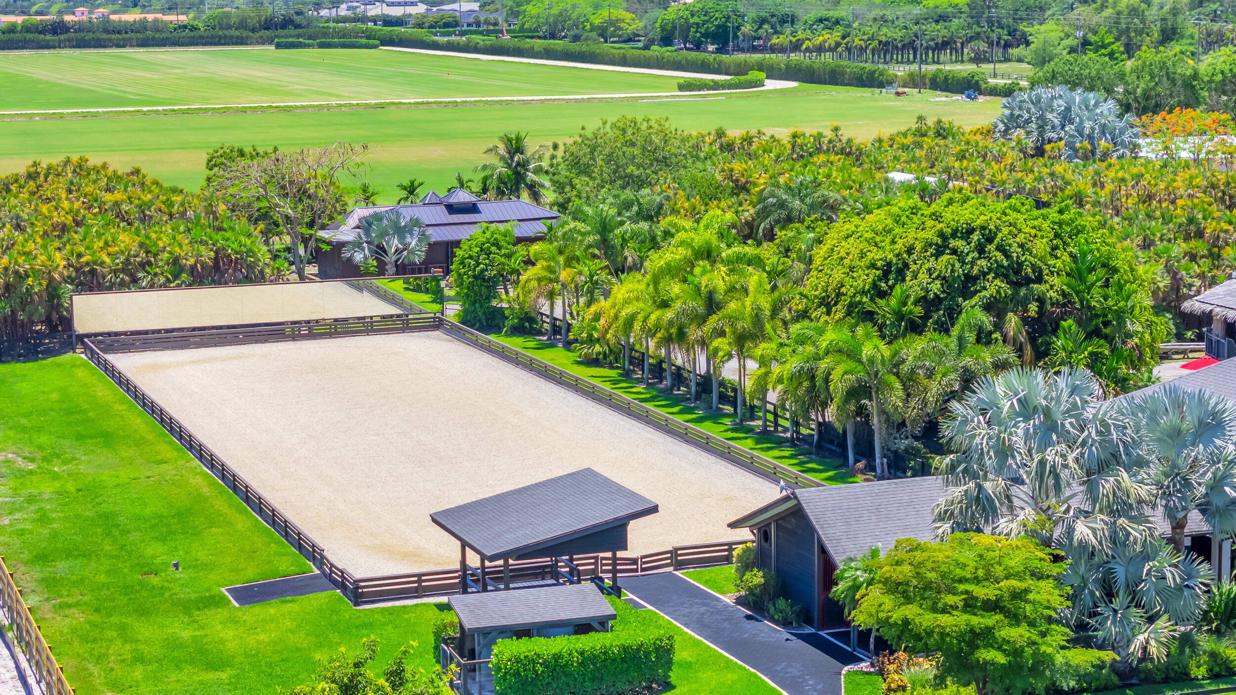 12880 Indian Mound Road Wellington, FL 33449 - Photo 31 of 43 a view of a backyard with lawn chairs under an umbrella