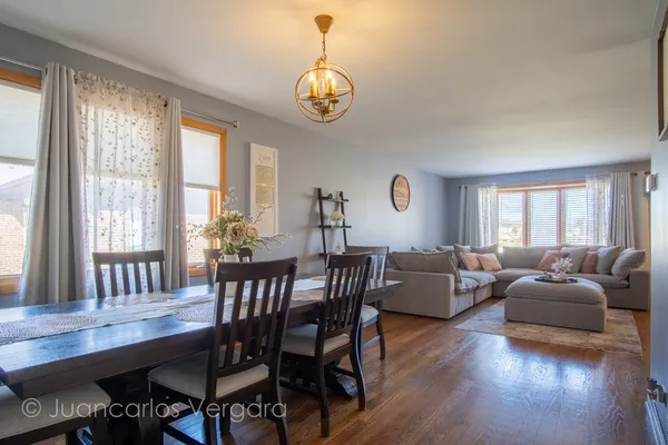 a view of a dining room with furniture a chandelier and wooden floor