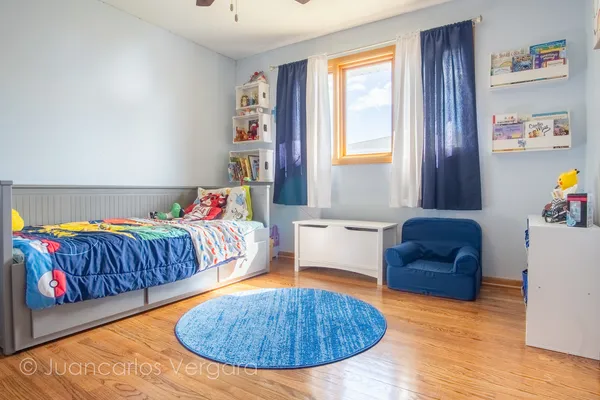 a view of a bedroom with wooden floor and cabinet