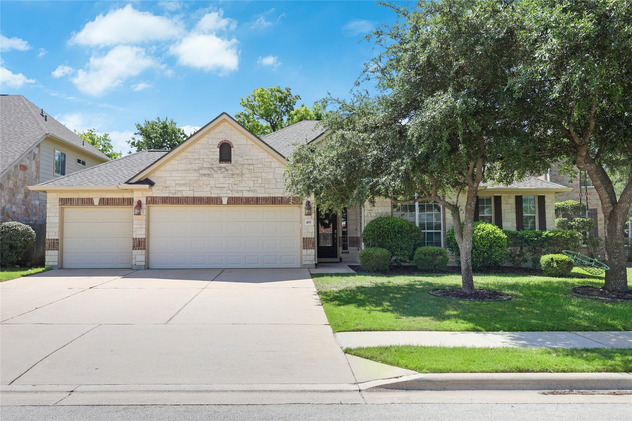 View of front facade featuring a garage, concrete driveway, brick siding, a front yard, and a shingled roof