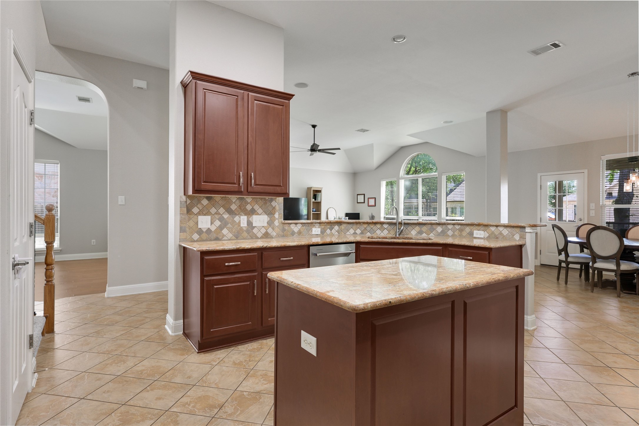 433 Ridgetop Bend Cedar Park, TX 78613 - Photo 15 of 34 Kitchen featuring a peninsula, lofted ceiling, light stone countertops, arched walkways, and a kitchen island