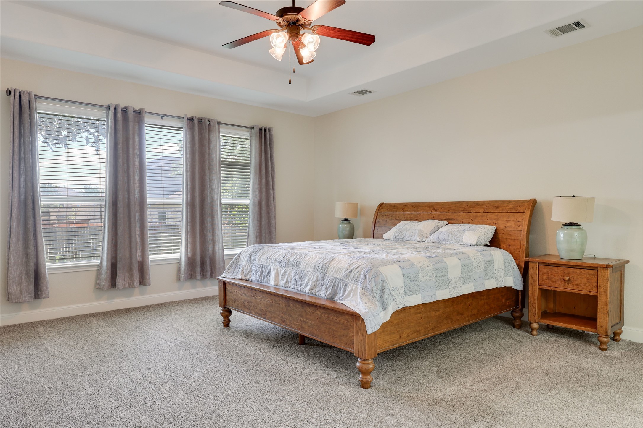 433 Ridgetop Bend Cedar Park, TX 78613 - Photo 19 of 34 Bedroom featuring light carpet, a ceiling fan, and a raised ceiling