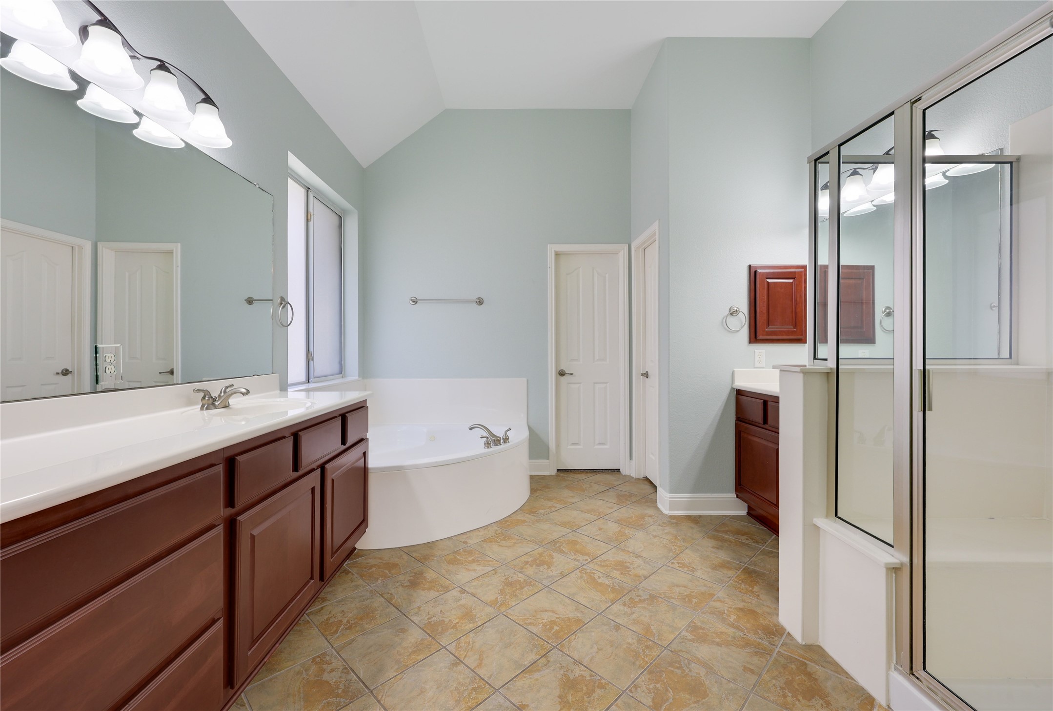 433 Ridgetop Bend Cedar Park, TX 78613 - Photo 21 of 34 Full bathroom featuring lofted ceiling, two vanities, a bath, and a stall shower