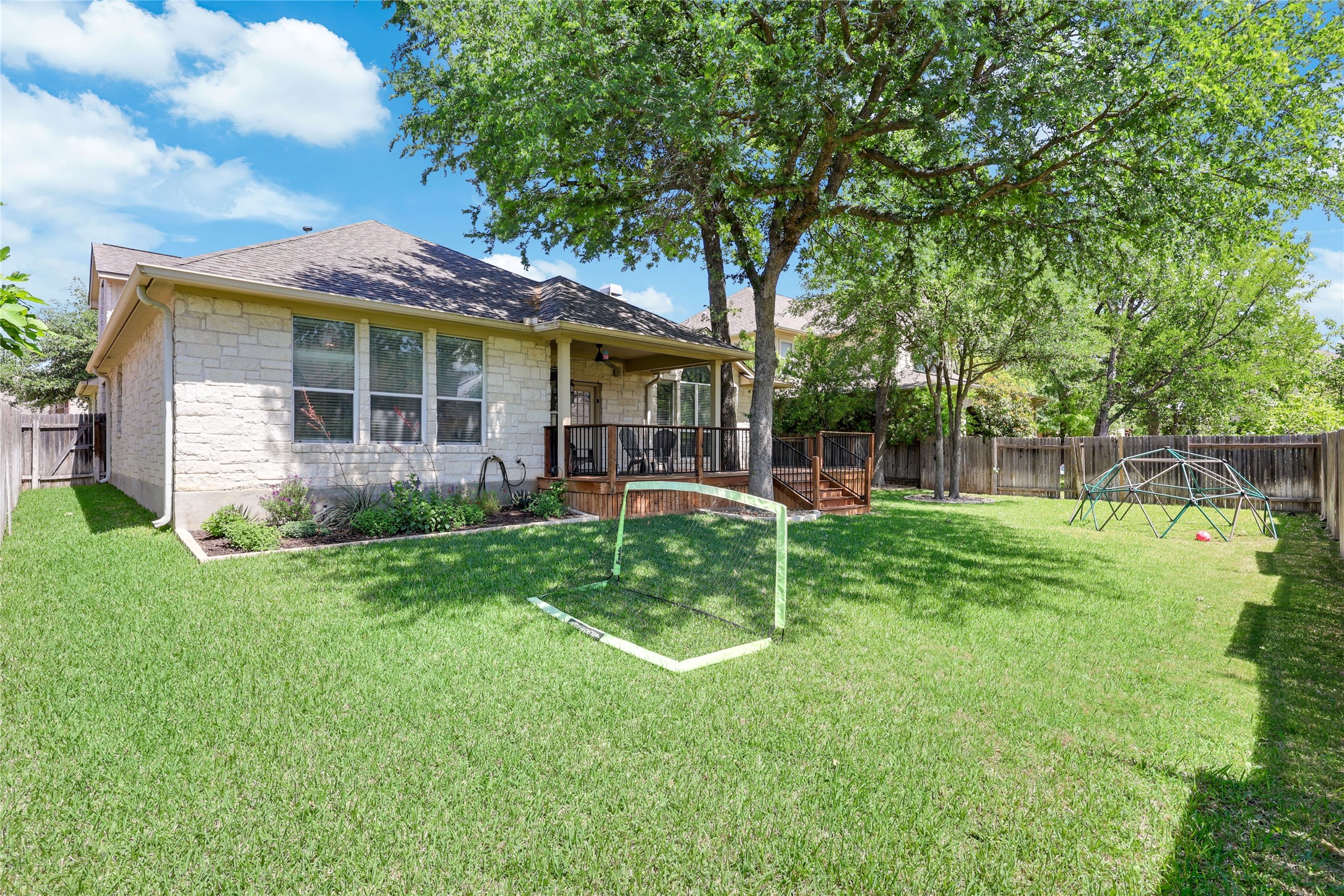 433 Ridgetop Bend Cedar Park, TX 78613 - Photo 28 of 34 Rear view of property with stone siding, a wooden deck, and a fenced backyard