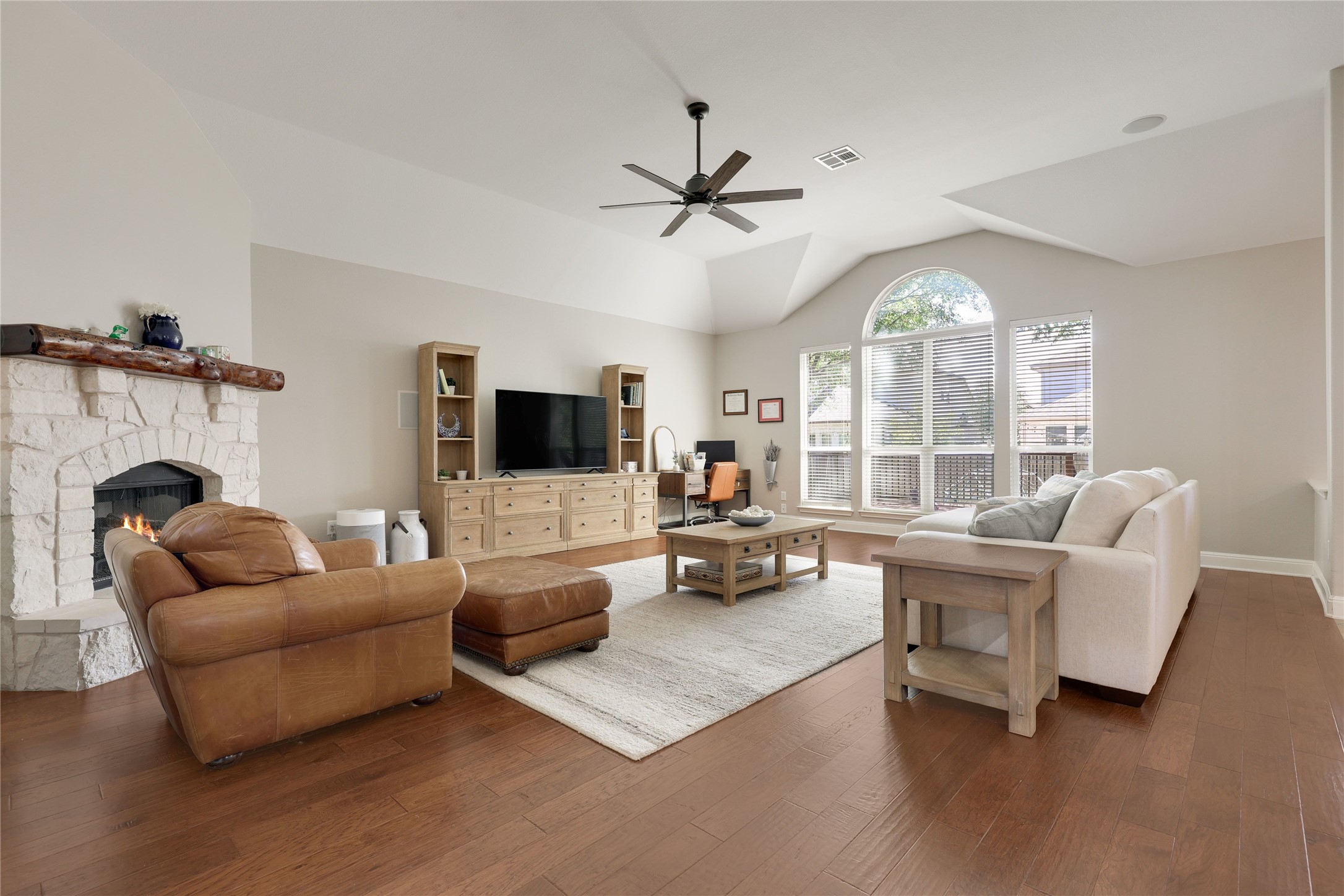 433 Ridgetop Bend Cedar Park, TX 78613 - Photo 6 of 34 Living room featuring dark wood-type flooring, a ceiling fan, a stone fireplace, and vaulted ceiling