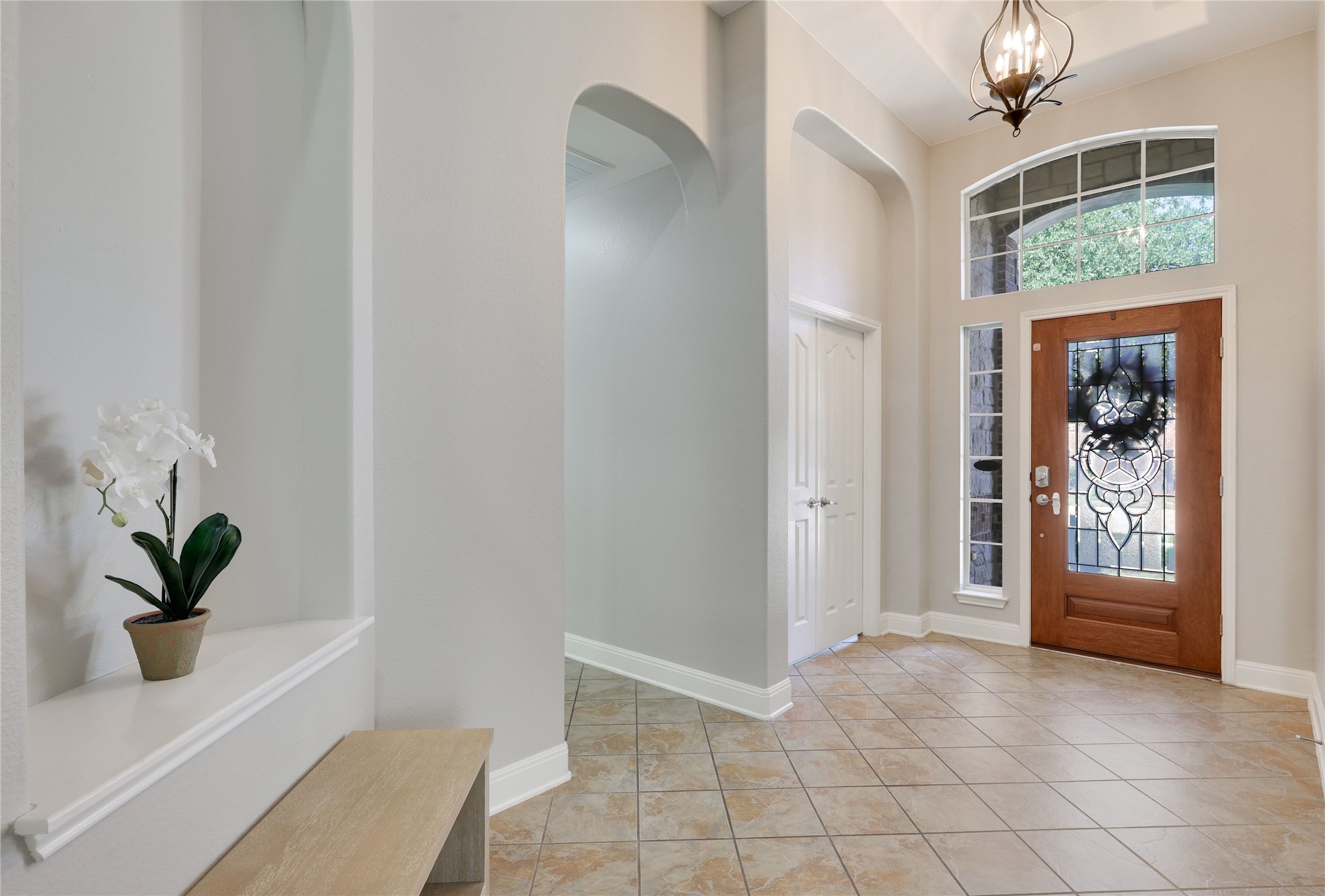 433 Ridgetop Bend Cedar Park, TX 78613 - Photo 7 of 34 Foyer featuring suspended lighting, a high ceiling, light tile patterned flooring, and arched walkways