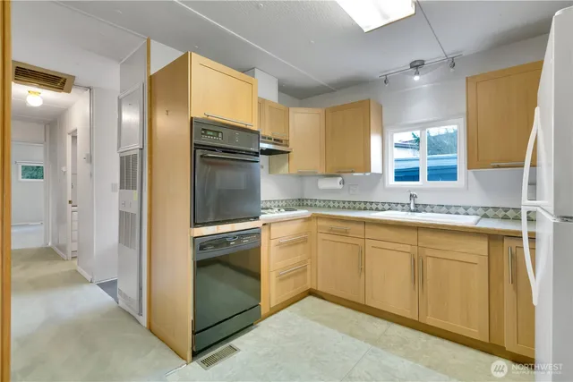 a kitchen with a refrigerator sink and cabinets