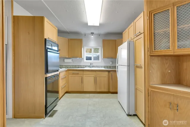 a kitchen with a refrigerator sink and cabinets