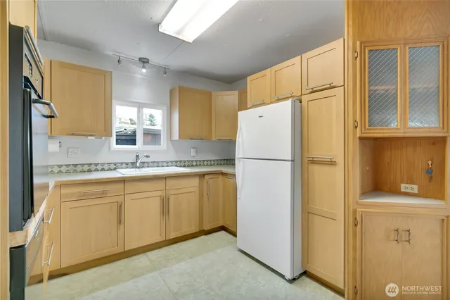 a kitchen with refrigerator a sink and cabinets