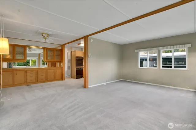 an empty room with a kitchen and windows