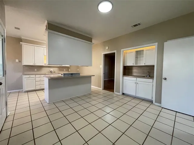 a kitchen with stainless steel appliances a stove a sink and white cabinets