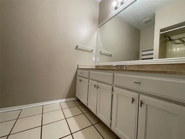 a bathroom with a granite countertop bathtub shower and toilet