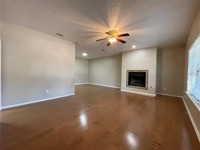 an empty room with windows and fireplace