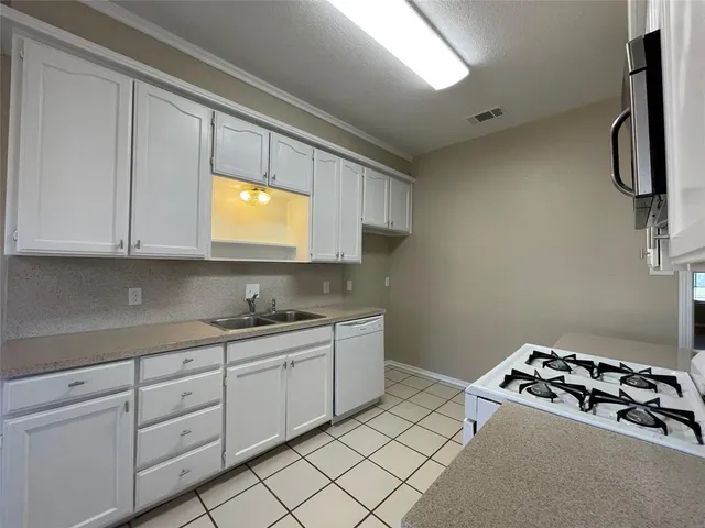 a kitchen with stainless steel appliances granite countertop a sink and a stove