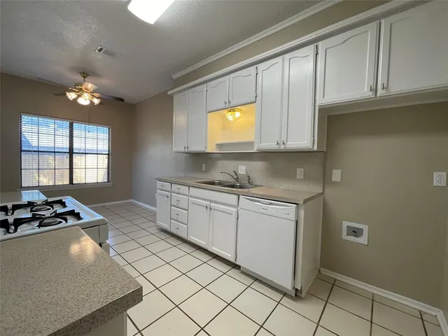 a kitchen with granite countertop cabinets and window