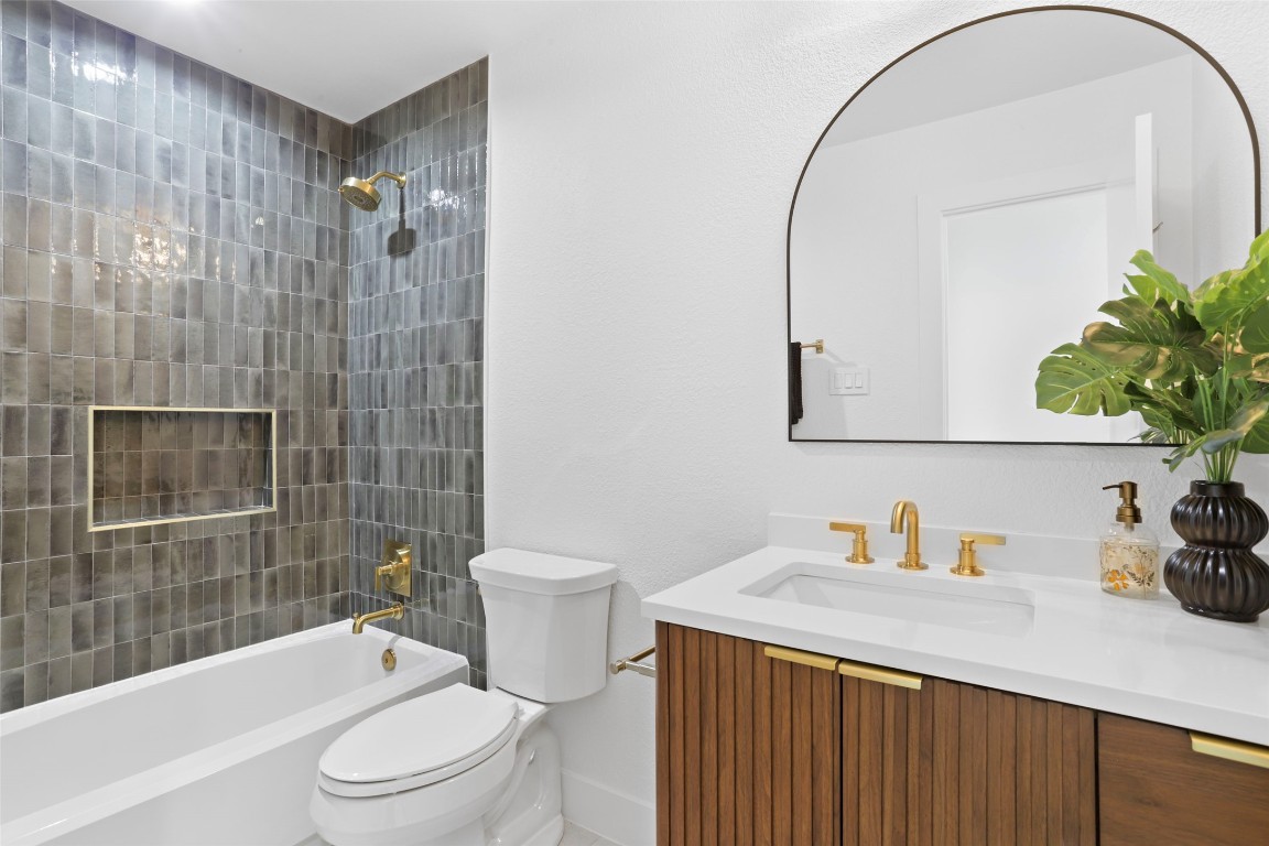 9229 Independence Loop Austin, TX 78748 - Photo 12 of 24 Full hall bathroom with fluted vanity and artisan tile